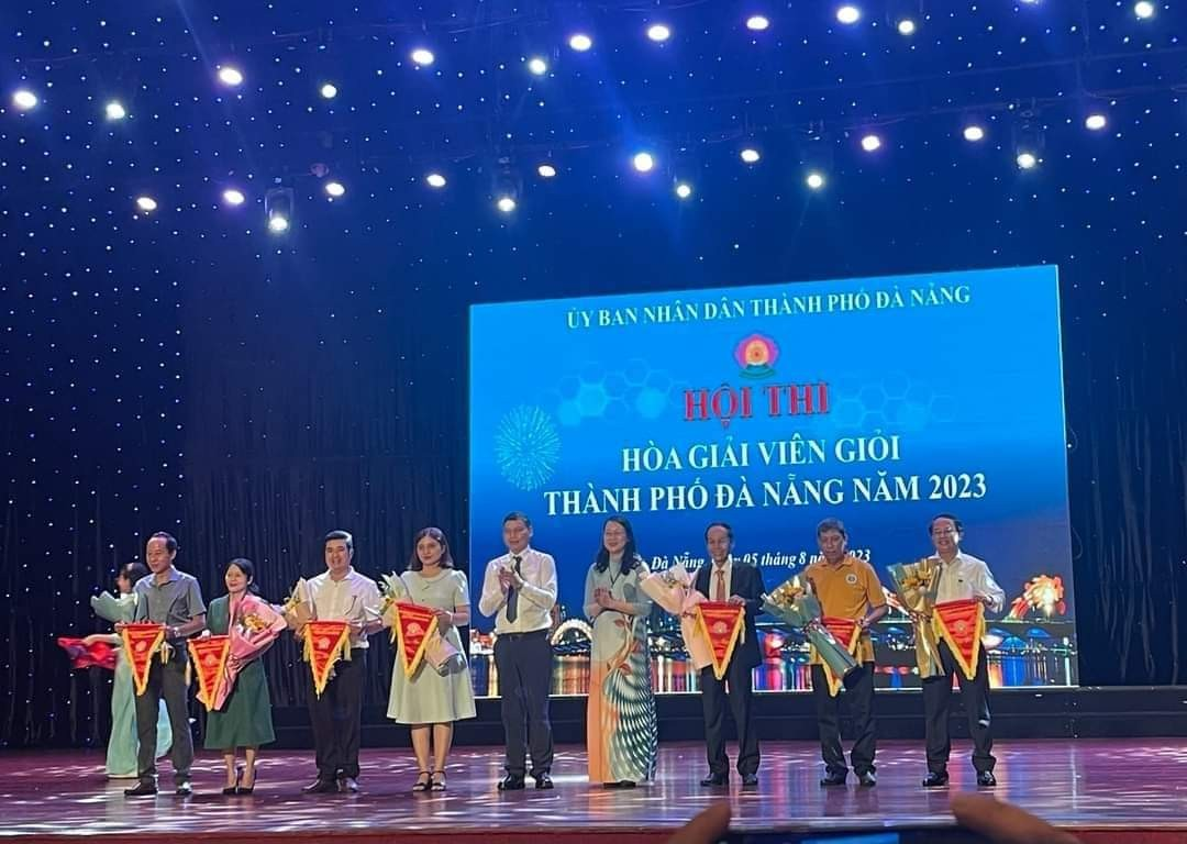 Ông Hồ Kỳ Minh Phó Chủ tịch Thường trực UBND thành phố  và bà Trần Thị Kim Oanh Giám đốc Sở Tư pháp - Trưởng ban Tổ chức Hội thi trao cờ lưu niệm cho các Đội thi.